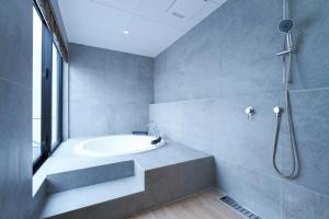 a bathroom with a tub and a sink and a shower at Grand Bleu Gamin in Miyako-jima +40 photos