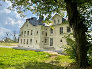 La RemuéeManoir de L'Oiselière的前方有树的大白色房子