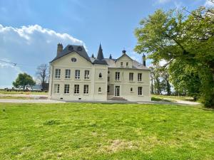 La RemuéeManoir de L'Oiselière的一座大型白色房子,设有大片草地