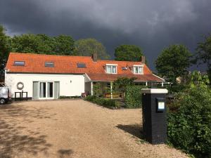 ein Haus mit einem orangenen Dach vor einer Einfahrt in der Unterkunft 't Zeeuwse licht in Middelburg