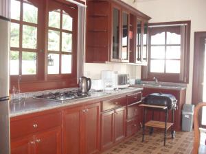 a kitchen with wooden cabinets and a stove top oven at Majestic Villas Phuket in Rawai Beach