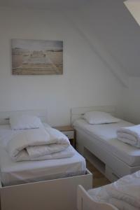 Maison-villa Quiberon, 5 personnes, jardin, proche du port, plages baie et océan في كويبيرون: سريرين في غرفة مع صورة على الحائط