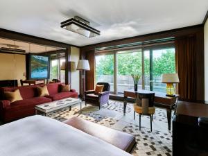 a living room with red furniture and a large window at 45 Park Lane - Dorchester Collection in London