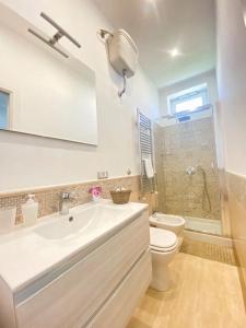a white bathroom with a sink and a toilet at La Primavera in Anacapri