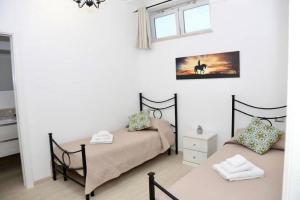 a bedroom with two beds and a window at La Primavera in Anacapri