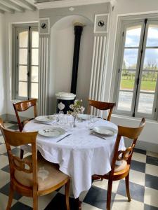 uma mesa de jantar com uma toalha de mesa branca em Manoir de L'Oiselière em La Remuée