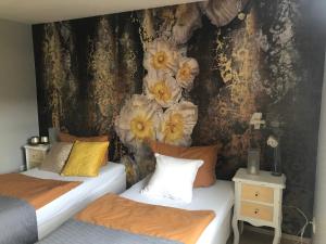 two beds in a room with flowers on the wall at Ferienwohnung Laaslich in Laaslich