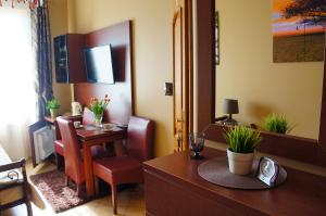 a hotel room with a desk and a dining room at POKOJE GOŚCINNE ATOL in Hel