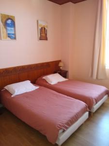 two beds sitting next to each other in a bedroom at Villa Le Cid in Soulac-sur-Mer