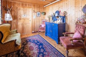 Habitación con paredes de madera, armario azul y sillas. en Fyresdal Gjestehus, en Moland