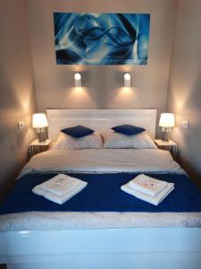 a bedroom with a bed with two towels on it at GARDENIA BLUE APART Dziwnów z widokiem na morze in Dziwnów