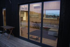 a room with a sliding glass door with a living room at Aitvaru Terasos in Svenele