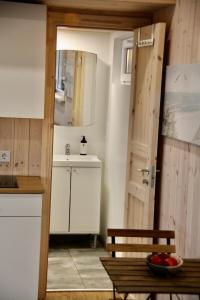 a kitchen with a sink and a table with a bowl of fruit at AITVARU TERASOS apartamentai pirmame aukšte su terasa į kanalą in Svenele +47 photos