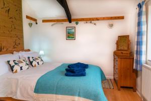 ein Schlafzimmer mit einem Bett mit einer blauen Decke darauf in der Unterkunft Polrunny Farm Blackberry Cottage - Cornwall bliss in sight of the sea in Boscastle