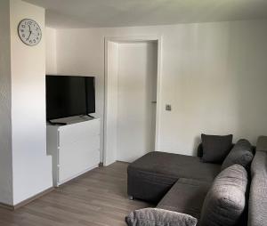 a living room with a couch and a flat screen tv at Ferienwohnung Venwegen in Venwegen
