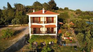 a white house with a red roof on a hill at House Antaya in Nikiti