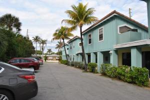 a blue building with palm trees on the side of a street at Sand Dune Shores, a VRI resort in Palm Beach Shores