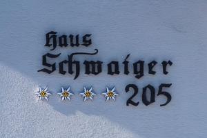 マリアプファルにあるGästehaus Schwaigerの白壁の花の看板