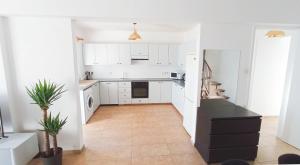 a kitchen with white cabinets and a black counter top at Luxury private rooms -SEA VIEW, NETFLIX, GYM- 5 Min from beach! - private room in shared apartment in Larnaca