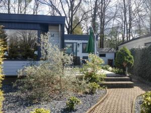 un jardín frente a una casa con patio en Traum-Chalet für Urlauber in Putten an der Veluwe Krachtighuizerkern 22 & free Bikes, en Putten
