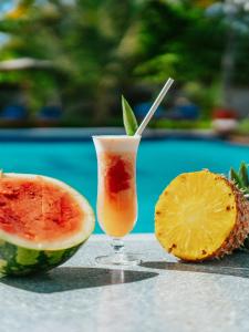 a drink in a glass next to a slice of watermelon at Sunny Palms Beach Bungalows in Zanzibar City
