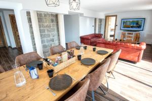 uma sala de jantar com uma longa mesa de madeira e cadeiras em Moho Mountain Home em Gérardmer