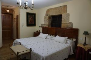 1 dormitorio con 1 cama grande y pared de piedra en Apartahotel Montecaoru, en Arenas de Cabrales