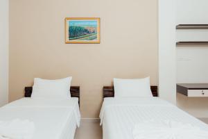 duas camas sentadas uma ao lado da outra num quarto em Corner One Residence em Hat Yai