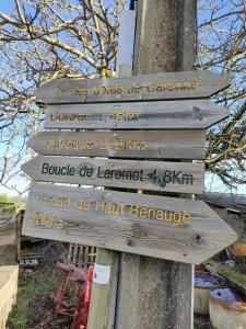 a wooden sign attached to a tree with writing on it at L Atelier Demoiselle in Cadillac