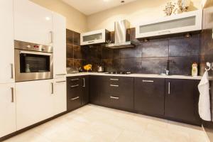 a kitchen with black and white cabinets and appliances at Apartament Lidia in Duszniki Zdrój