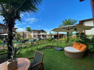 a patio with a table and an umbrella at Apartamento em barra grande - Villaggio di Mare - apto 02 bl 04 - Garden in Barra Grande
