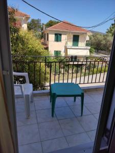 a balcony with a green table and a bench at Kohyli in Lefkada Town