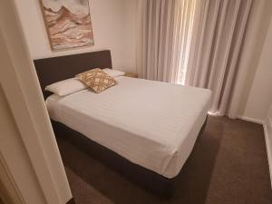 a bedroom with a large bed with white sheets and pillows at Mildura Holiday Homes - 15th Street in Mildura