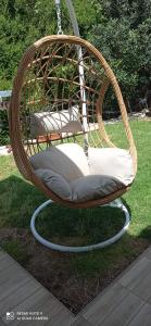 a wicker swing chair sitting in the grass at Beit Haner Moshav Dor in Dor