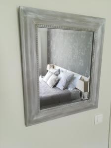 een spiegel aan de muur met een bed met kussens bij Chambres La Belle Vue in Dinant