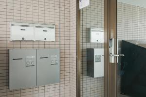 ein gefliestes Badezimmer mit zwei Maschinen an einer Wand in der Unterkunft Mon Petit Chat in Kanazawa