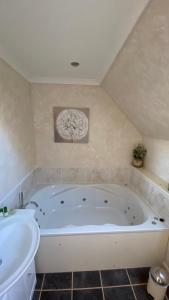 a large white bath tub in a bathroom at Tor View in Portree