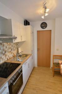 una cocina con fregadero y un reloj en la pared en Appartement Gombotz en Halbenrain