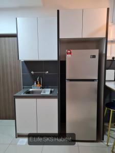 een keuken met een koelkast en een wastafel bij E Life SKS Habitat With WiFi Netflix in Johor Bahru