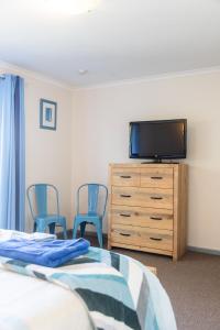 a bedroom with a tv and a bed and chairs at Relax in San Remo in San Remo