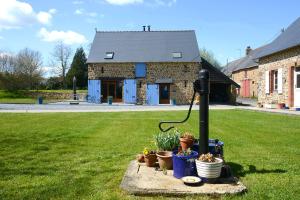 ein Haus mit einem Garten mit Topfpflanzen davor in der Unterkunft La Martinière in Saint-Aubin-Fosse-Louvain