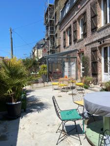 een patio met stoelen en een tafel voor een gebouw bij L entrepote in Dieppe