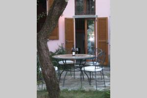 un tavolo e sedie di fronte a una casa rosa di Romantica La Filanda a Sala Comacina