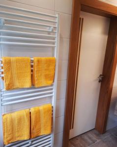 a towel rack with yellow towels in a bathroom at Apartment Fischer mit Privatstrand in Steindorf am Ossiacher See