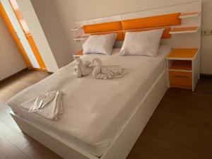 a white bed with two stuffed animals on it at City Central Apartment in Yerevan +135 photos