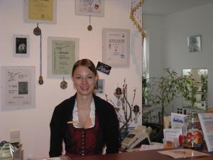 a woman sitting at a desk with a phone at Alpenhotel Allgäu in Hohenschwangau