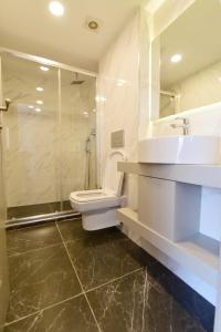 y baño con aseo, lavabo y ducha. en Serai Hotel, en Estambul