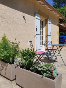 een tafel en stoel buiten een huis bij le bois du bournat in Saint-Avit-Sénieur