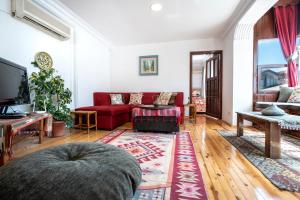 a living room with a red couch and a tv at Beach House Apartment in Side