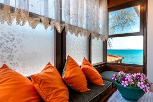 a window seat with orange pillows and a vase of flowers at Beach House Apartment in Side